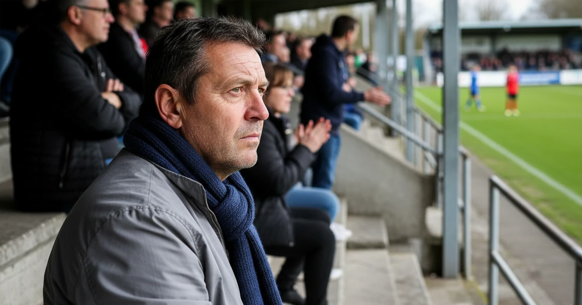 Aficionado local viendo un partido de fútbol en un estadio pequeño
